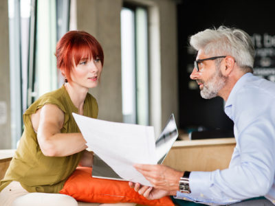 Two business people in workplace. Woman and man in creative office consulting a project together.